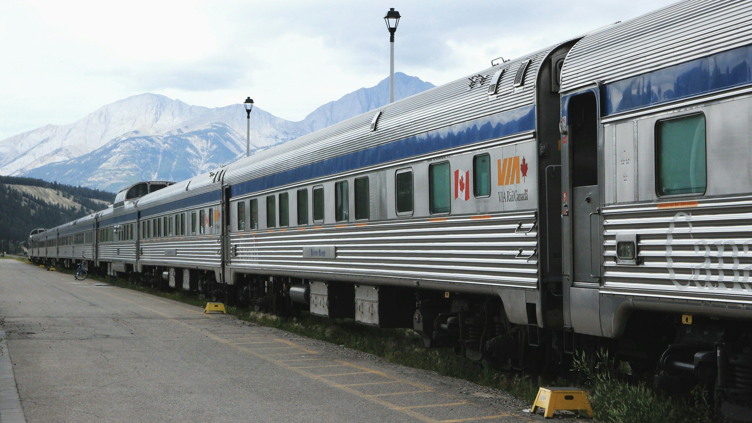 A stainless steel passenger train waiting at a station platform