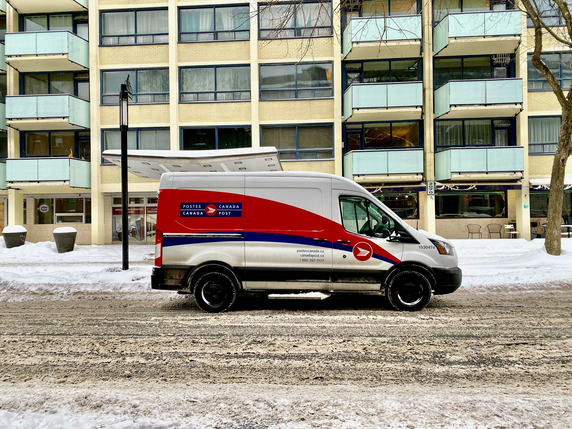 Canada Post van parked beside a building