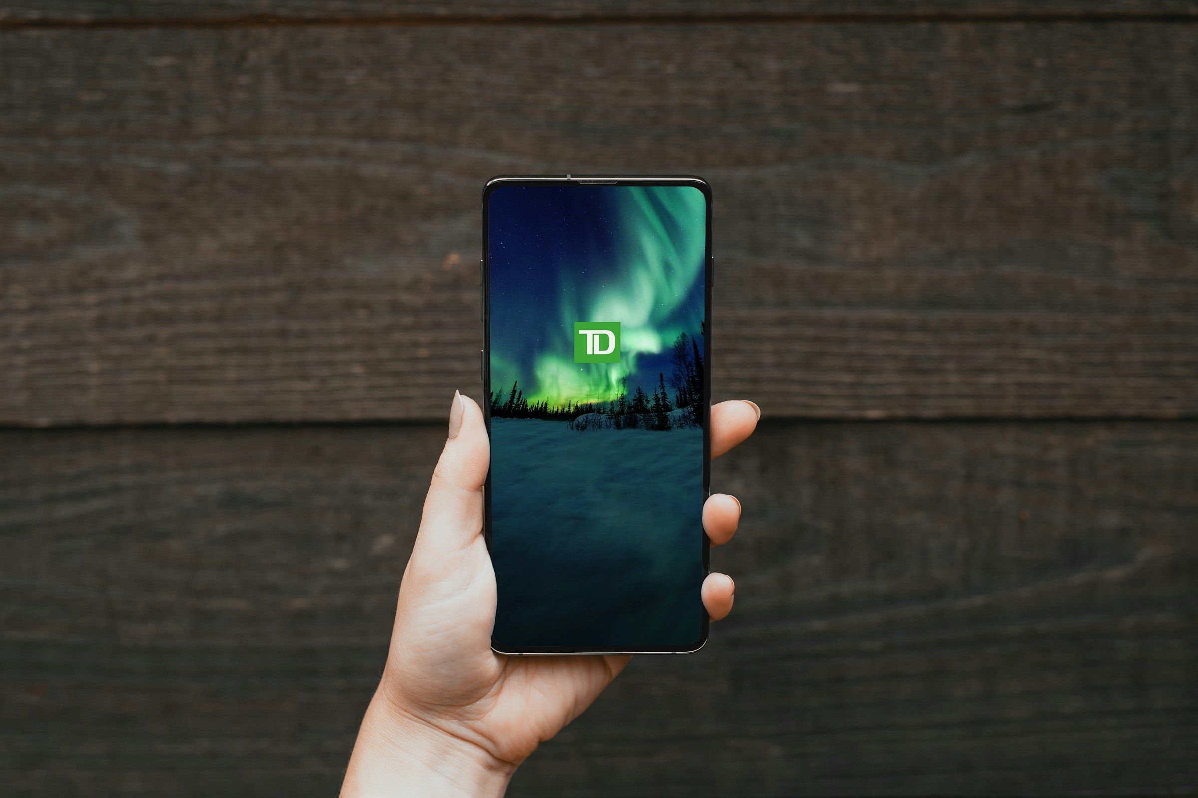 Person holding a cellphone with a green screen