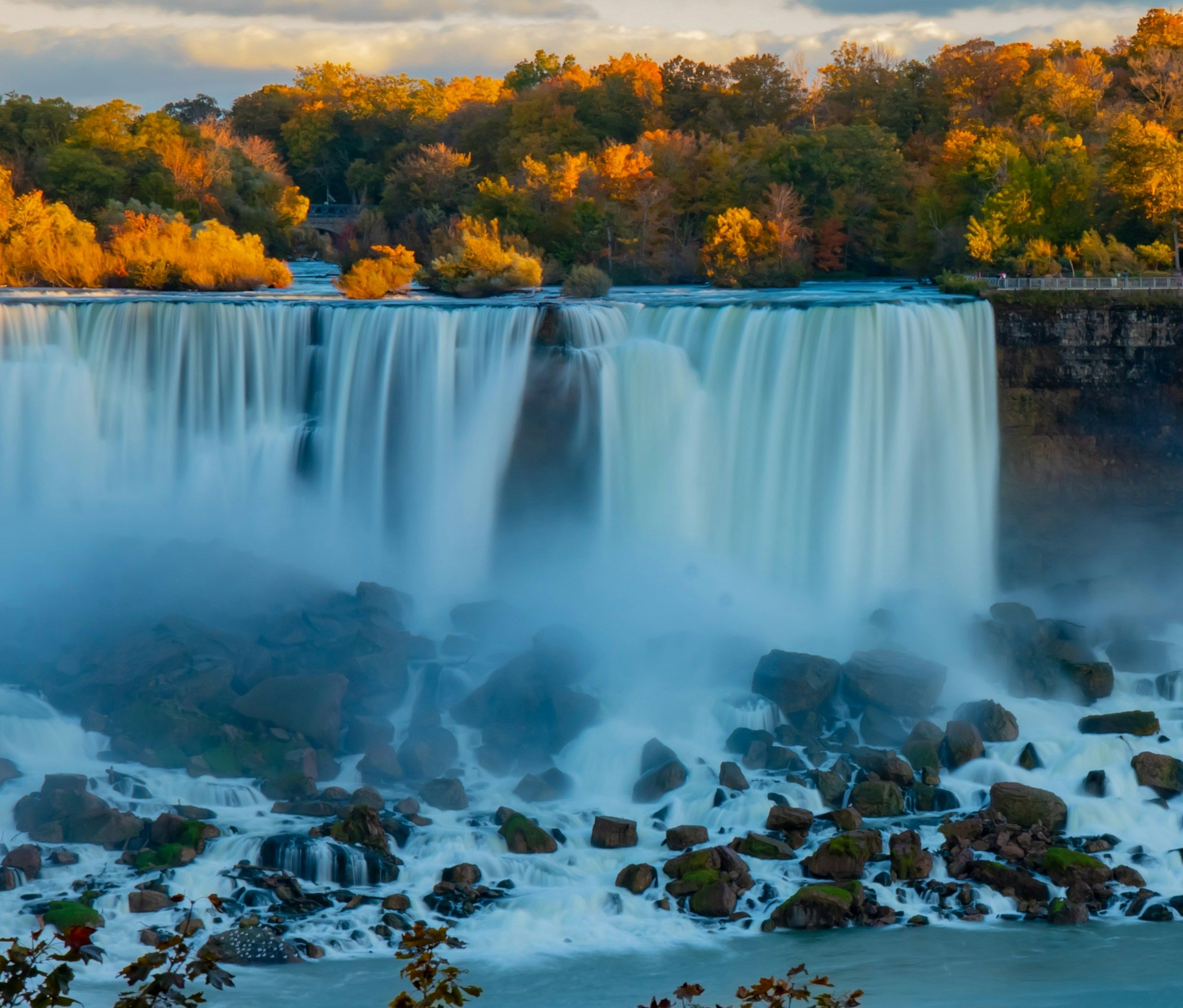 Niagara Falls seen from the Canadian side with autumn trees along the gorge