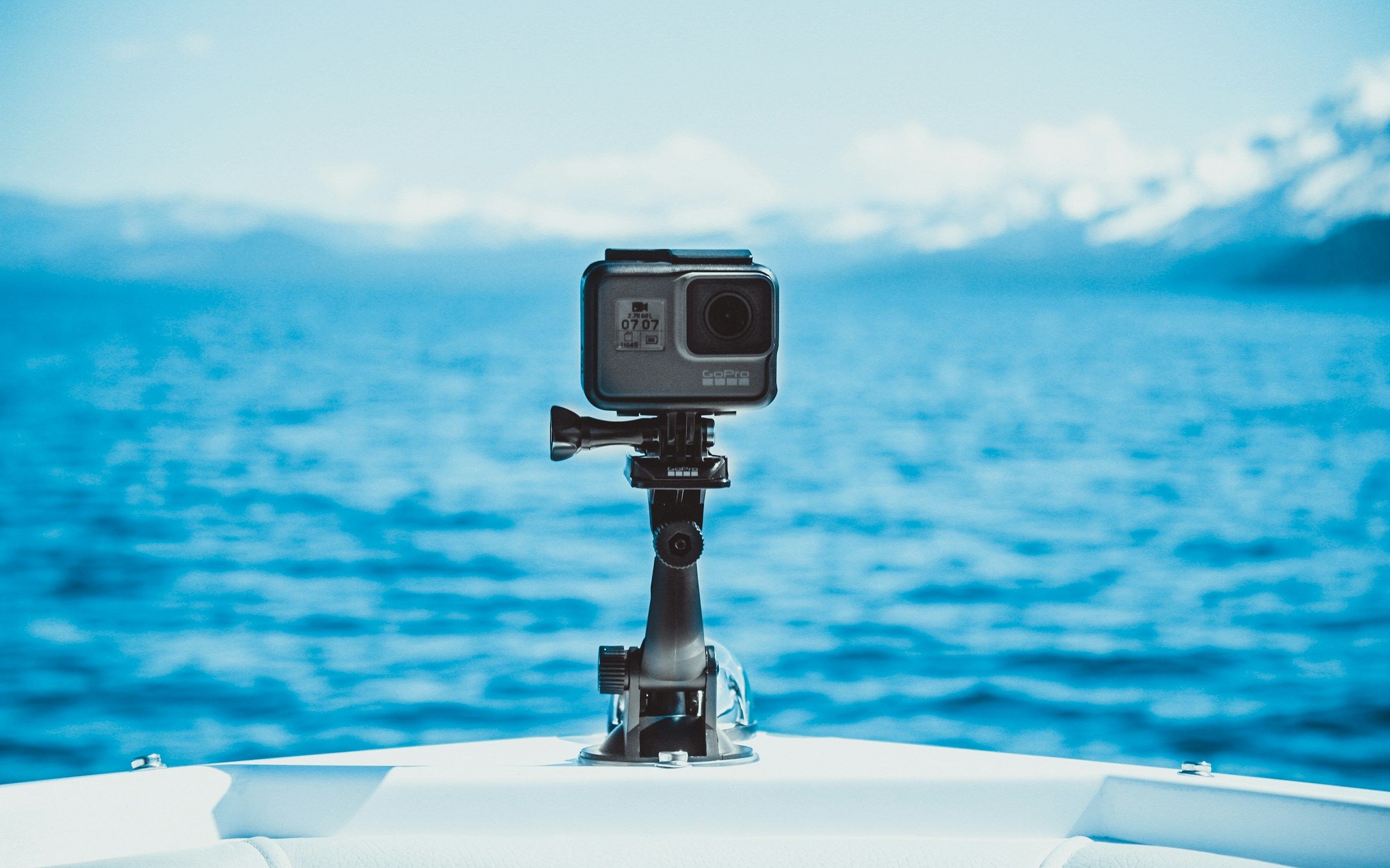 Action camera mounted outdoors with Lake Tahoe and snow-covered mountains in the background