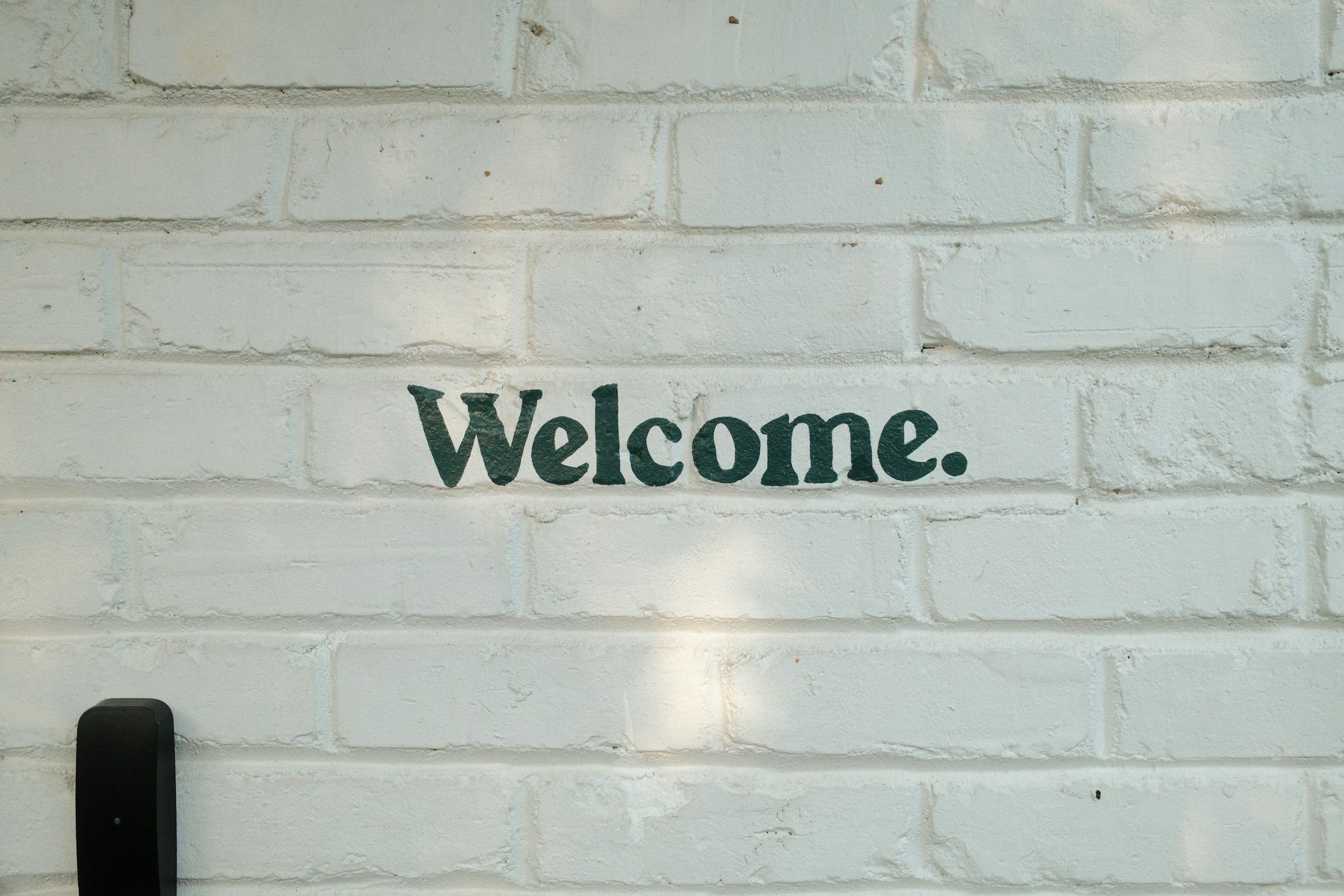 Welcome sign on a brick wall