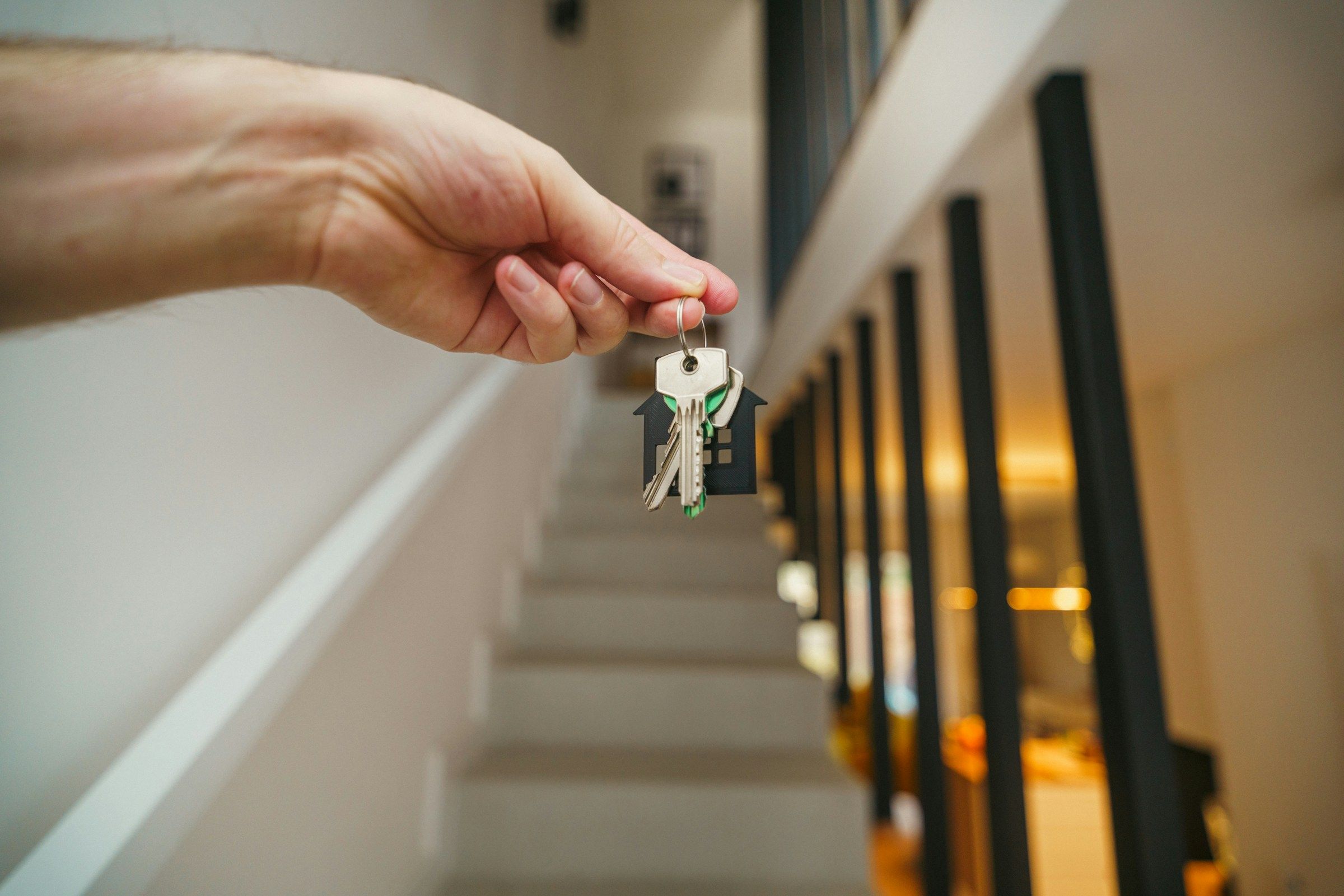 Keys being held in front of a staircase