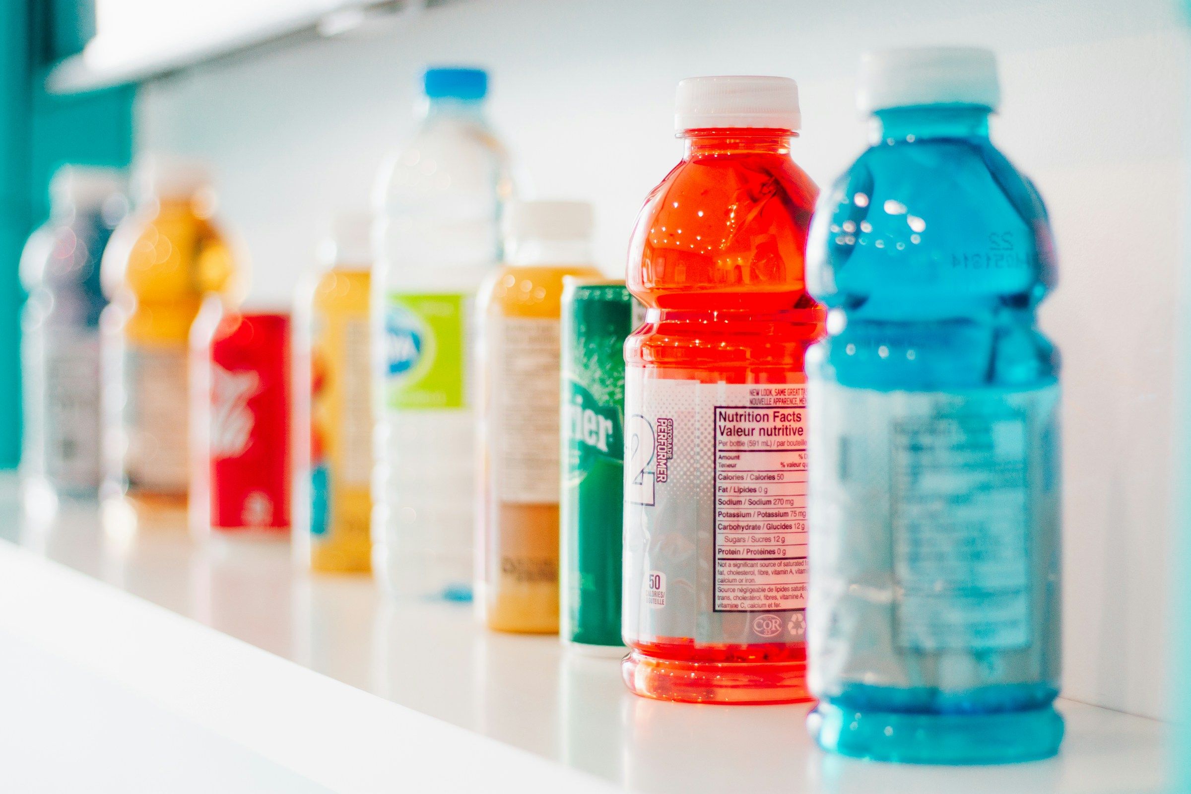 Rows of green and white sports-drink bottles on a store shelf.