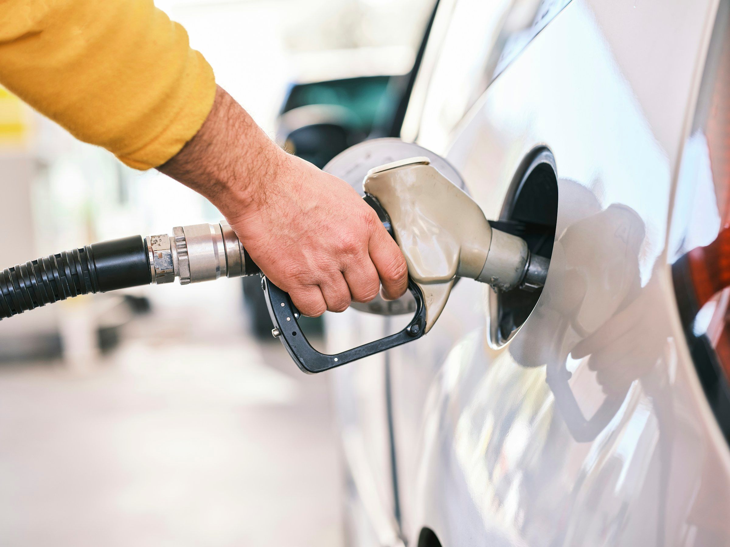 A man pumping gas into a car at a gas station