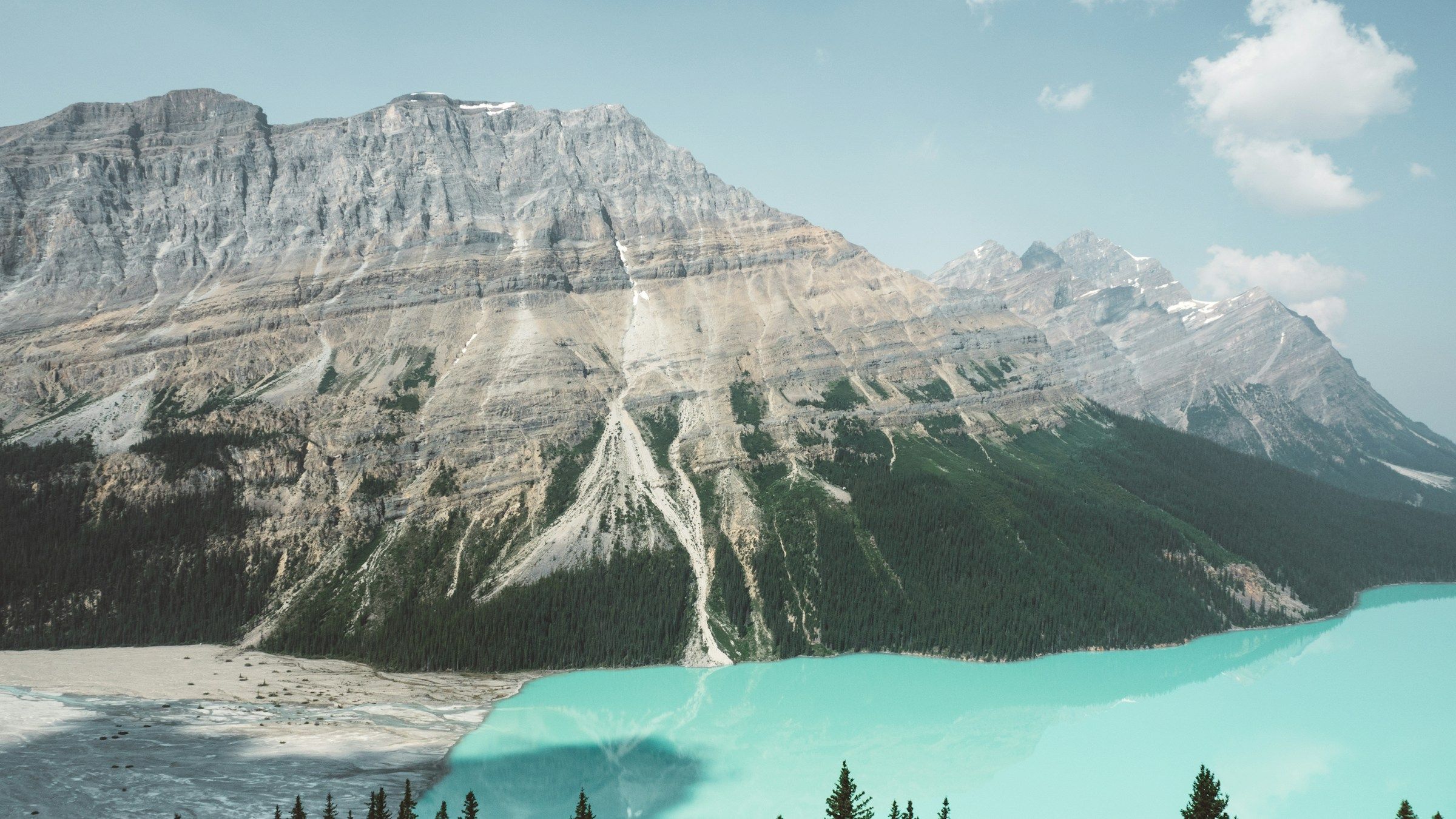 Mountain peaks rising behind a turquoise Canadian lake