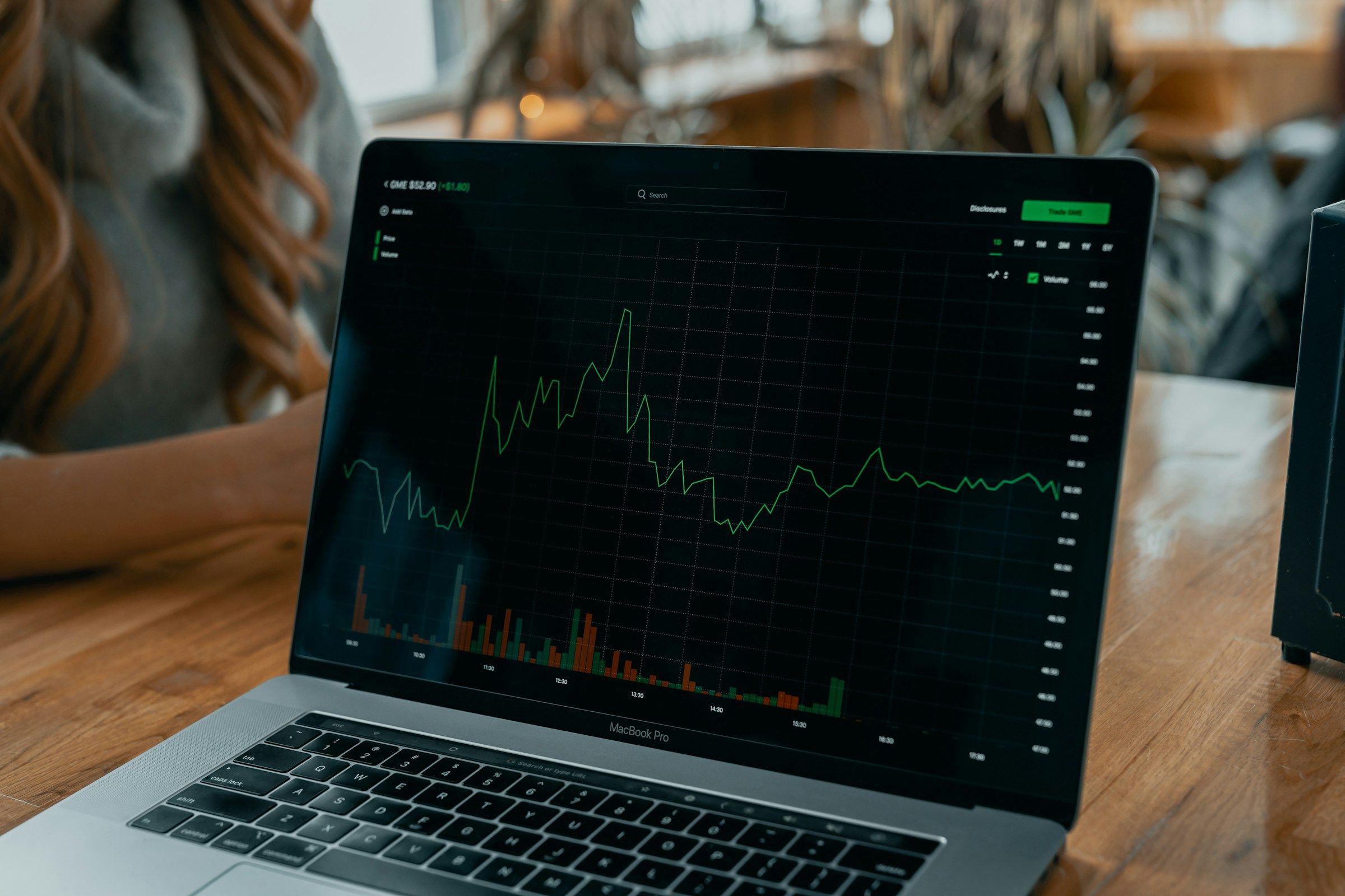 Laptop showing a stock chart on a desk