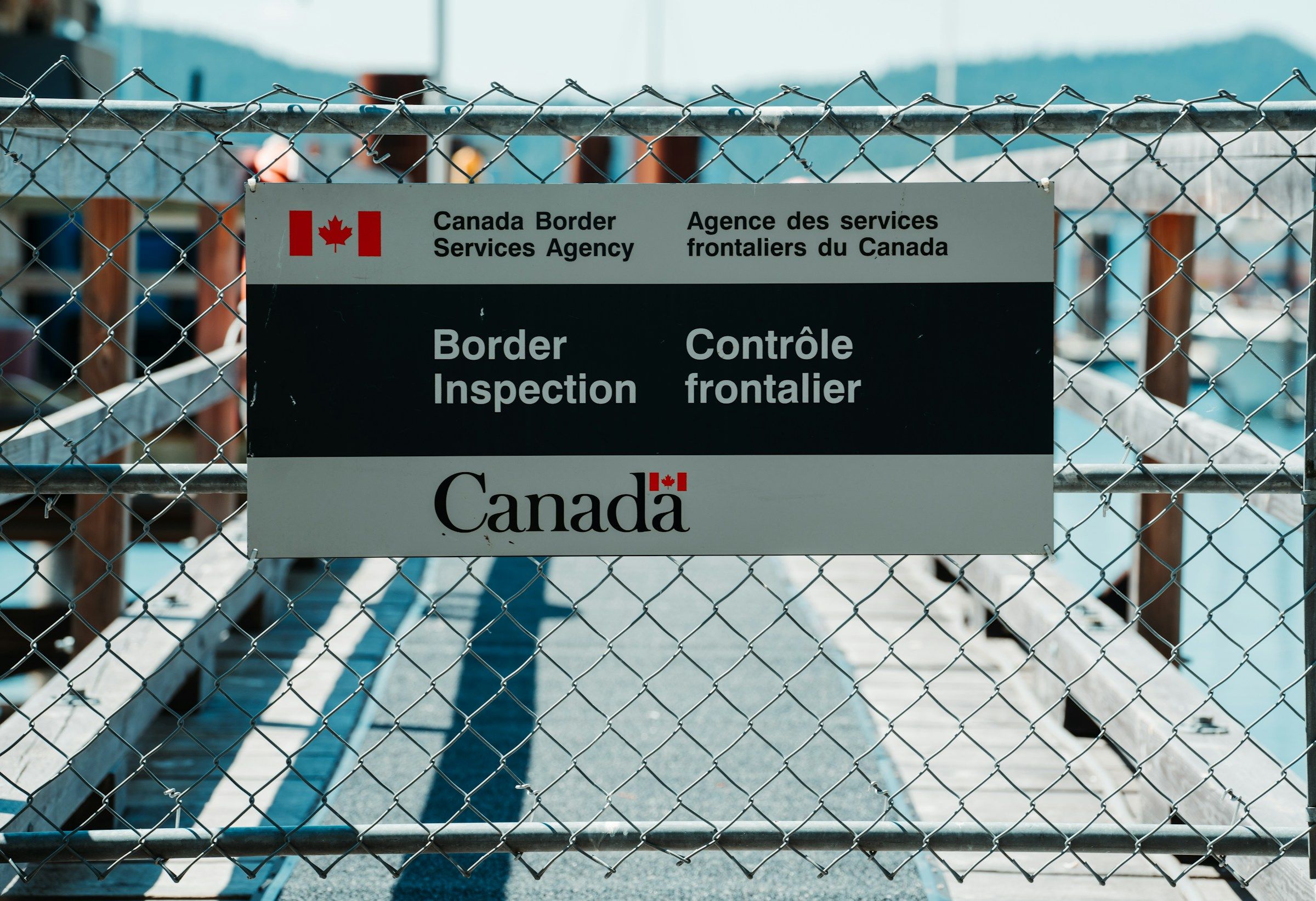 Blue and white metal fence at the Canada border